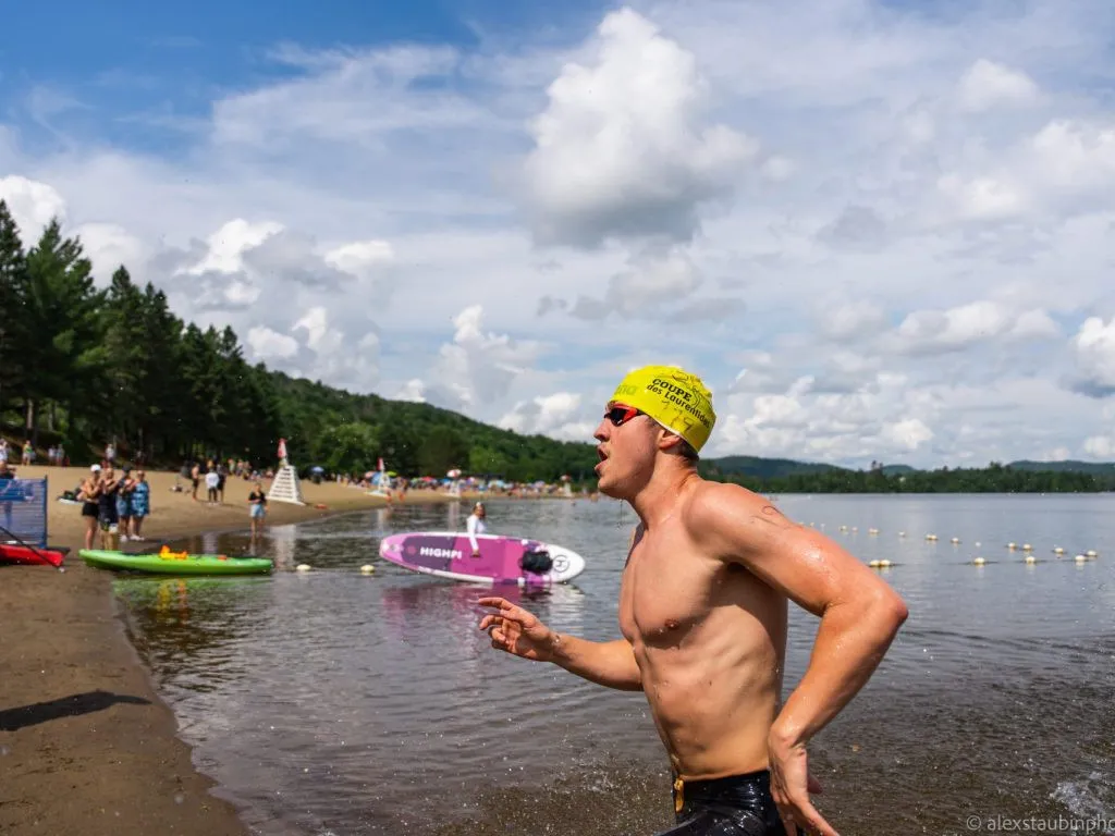 un nagueur sort des eaux du lac avec un bonnet jaune