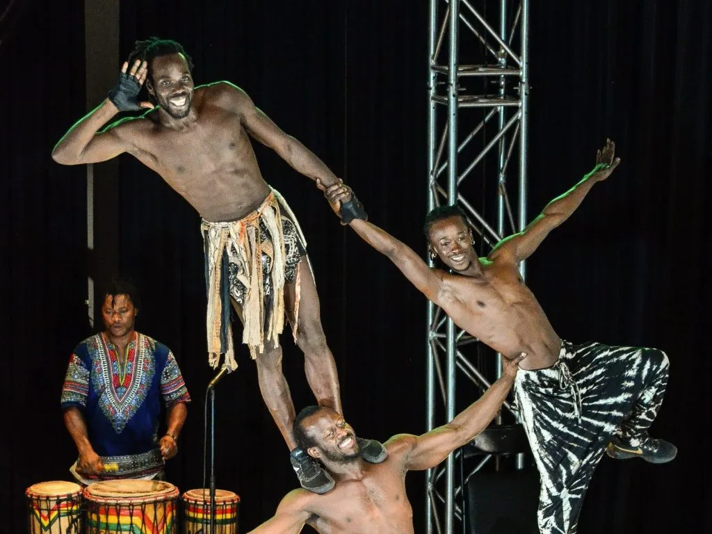 trois acrobates formes un traingle vertigineu avec leur corps