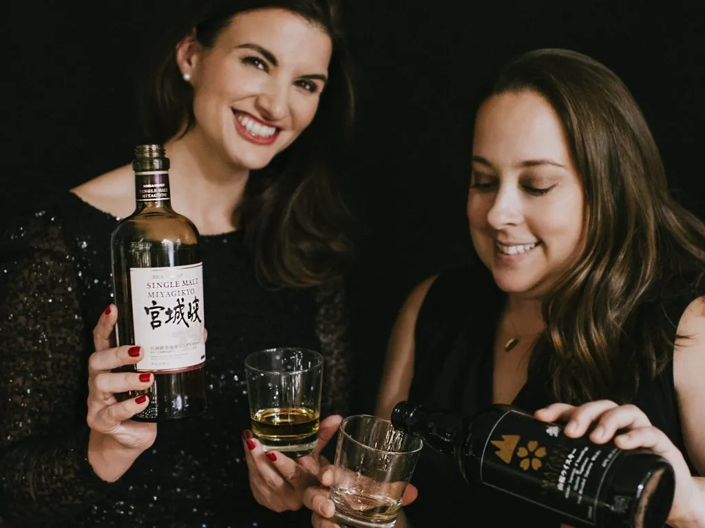 Des sommelières souriantes qui versent de l'alcool dans des verres