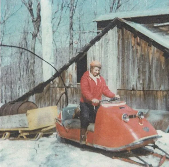 Une motoneige devant un ecabane à sucre dans les années 1980