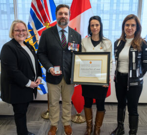 Groupe de gens dont l'un tient un certificat