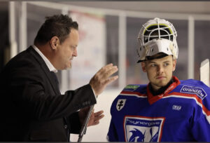 Un homme habillé propre discute avec un joueur de hockey peu attentif.